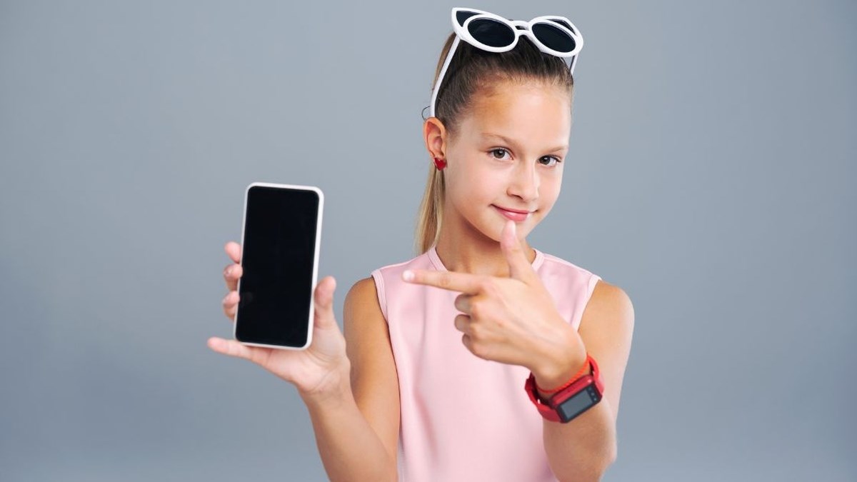 Starší dítě s chytrými hodinkami a mobilním telefonem