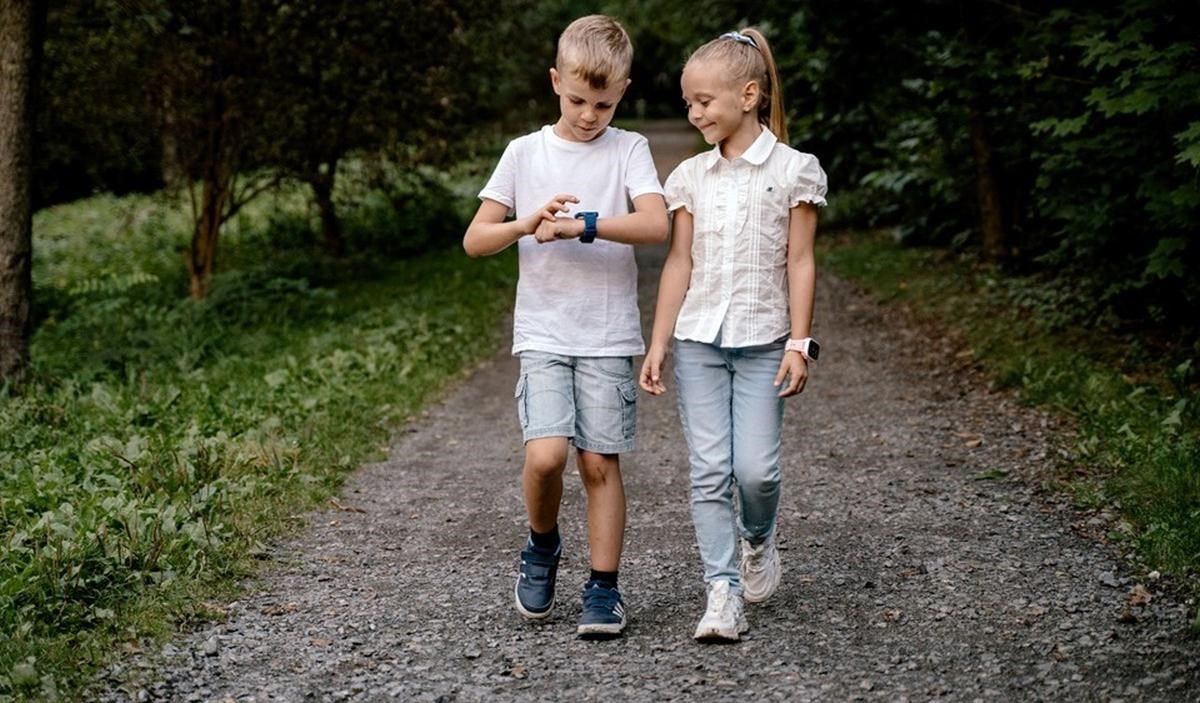 Děti na procházce používají chytré hodinky
