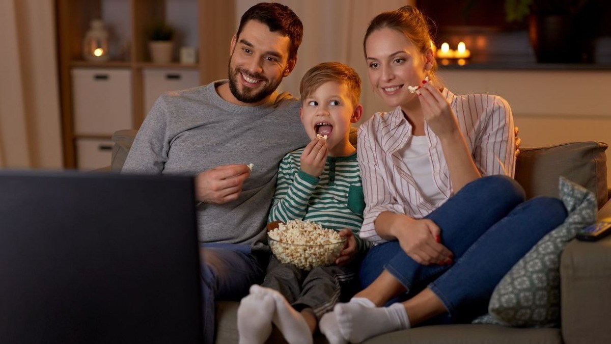 Rodina sleduje film v obýváku s kvalitním zvukem z domácího audio systému